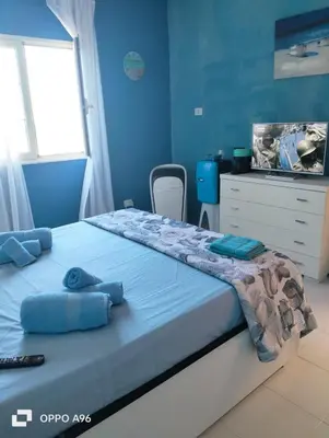 a bedroom with a large bed with blue walls at LA TERRAZZA SUL MARE camera fronte mare&vicino aereoporto SICILIAN VINTAGE STYLE SEASIDE ROOM in Cinisi