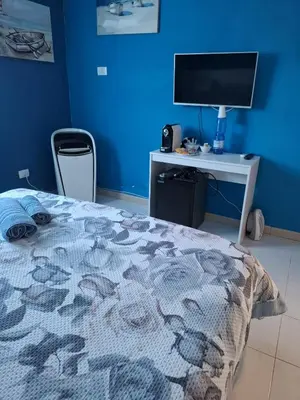 a bedroom with a bed and a desk with a television at LA TERRAZZA SUL MARE camera fronte mare&vicino aereoporto SICILIAN VINTAGE STYLE SEASIDE ROOM in Cinisi