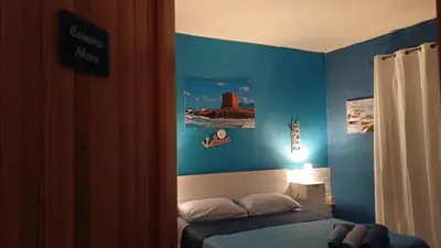 a bedroom with a bed and a blue wall at LA TERRAZZA SUL MARE camera fronte mare&vicino aereoporto SICILIAN VINTAGE STYLE SEASIDE ROOM in Cinisi