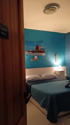 a bedroom with a bed with a blue wall at LA TERRAZZA SUL MARE camera fronte mare&vicino aereoporto SICILIAN VINTAGE STYLE SEASIDE ROOM in Cinisi
