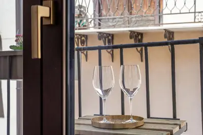 two wine glasses sitting on a ledge on a balcony at Venere - Alle Spalle del Teatro Massimo in Palermo