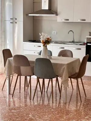 a dining room table with chairs and a vase of flowers at Kasa Stabile in Palermo