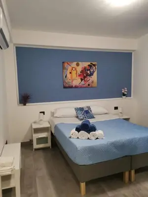 a bedroom with a bed with a blue wall at Casa Vacanze il Cortile in Casteldaccia