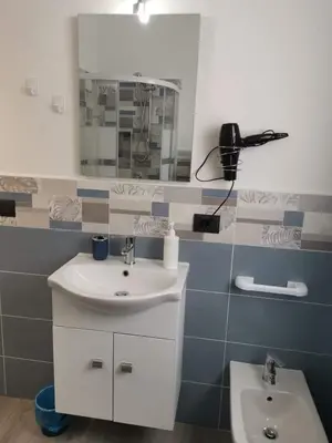 a bathroom with a sink and a mirror at Casa Vacanze il Cortile in Casteldaccia