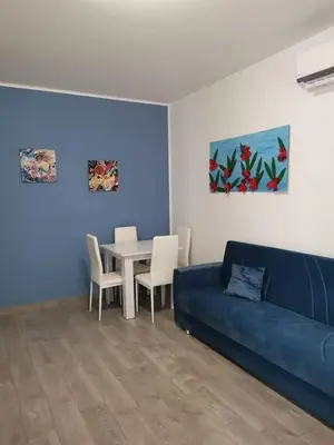a living room with a blue couch and a table at Casa Vacanze il Cortile in Casteldaccia