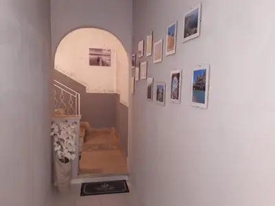 a hallway with a staircase with pictures on the wall at La casa di Ross in Casteldaccia