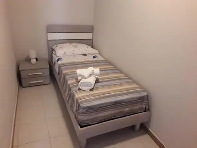a small bed with towels on it in a room at La casa di Ross in Casteldaccia