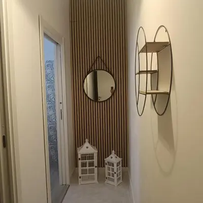 a hallway with a mirror and a shelf on a wall at Sole e mare 1 in Isola delle Femmine