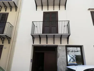 a building with a balcony and a door at Cassari Maisons in Palermo