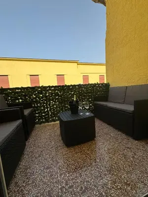 a patio with couches and a table in front of a wall at Karma House in Palermo