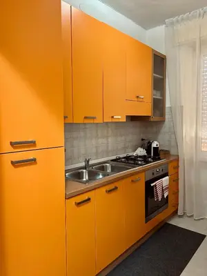 a kitchen with orange cabinets and a sink at Casa Iohana in San Vito lo Capo