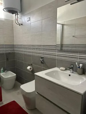 a bathroom with a sink and a toilet and a mirror at Casa Iohana in San Vito lo Capo