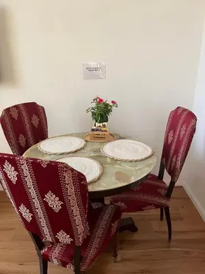 a dining room table with two chairs and a vase with flowers at Aurora Center City - Rooms in Palermo