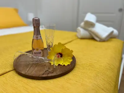 a bottle of champagne and a flower on a table at Aurora Center City - Rooms in Palermo