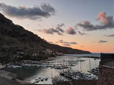a group of boats docked in a river at sunset at Casa Marina con vista sul castello in Castellammare del Golfo
