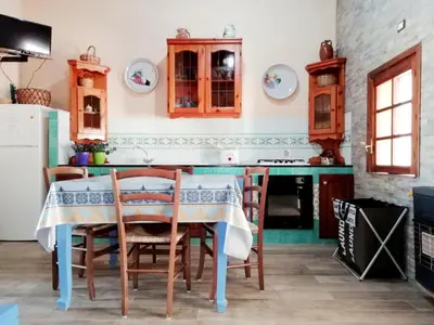 a kitchen with a table and chairs and a stove at Casa Marina con vista sul castello in Castellammare del Golfo