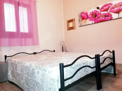 a bedroom with a bed and a painting on the wall at Casa Marina con vista sul castello in Castellammare del Golfo