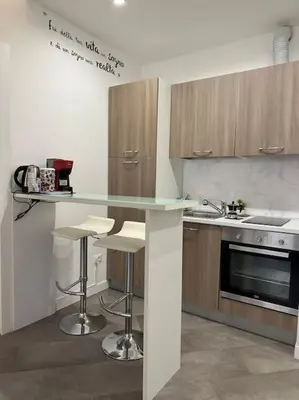 a kitchen with a counter with stools and a sink at coppola home in Palermo