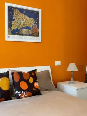 a bedroom with a bed with an orange wall at coppola home in Palermo