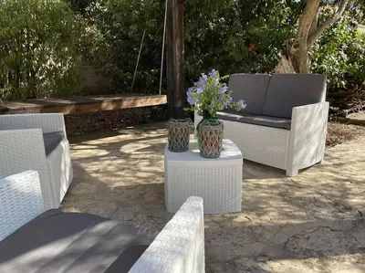 two chairs and a bench with flowers on a table at Villa Rubino ai Colli in Palermo