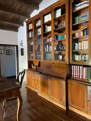 a library with wooden cabinets and book shelves with books at Villa Rubino ai Colli in Palermo