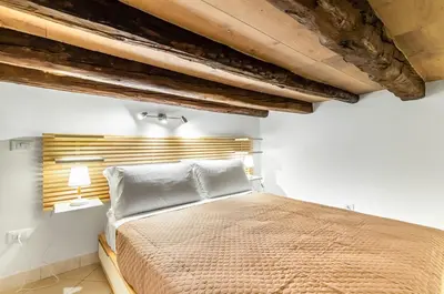 a bedroom with a bed and wooden ceilings at GuestHost - Central Station Modern Apartment with Balconies x8 in Palermo
