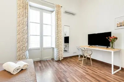 a living room with a desk and a television at GuestHost - Central Station Modern Apartment with Balconies x8 in Palermo