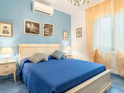 a blue bedroom with a bed and a window at Villa Olivella by Interhome in Cefalù