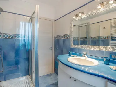 a blue bathroom with a sink and a shower at Villa Olivella by Interhome in Cefalù
