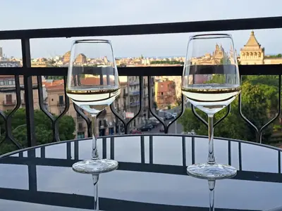 two glasses of white wine sitting on a balcony at Skyline Palermo in Palermo