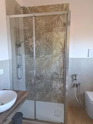 a shower with a glass door in a bathroom at Skyline Palermo in Palermo