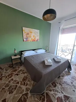 a bedroom with a large bed and a green wall at Skyline Palermo in Palermo