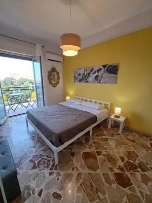 a bedroom with a bed and a yellow wall at Skyline Palermo in Palermo
