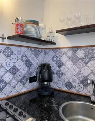 a kitchen with a sink and a counter with plates and glasses at Sicily guest house 2 in Palermo