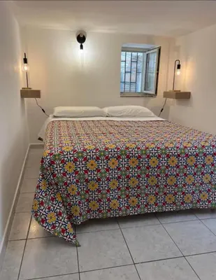 a bedroom with a bed with a colorful blanket on it at Sicily guest house 2 in Palermo