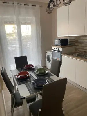 a kitchen with a table and chairs and a kitchen with a microwave at Panormus Guest Apartment in Palermo