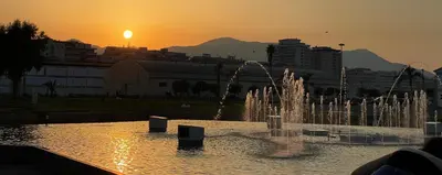 a fountain in a city with the sunset in the background at Panormus Guest Apartment in Palermo