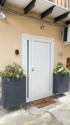 a white door with two potted plants on it at Apartment al Vicolo 27 in Palermo