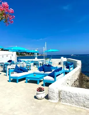 a group of blue benches sitting on the beach at Casa Sciàlari in Palermo