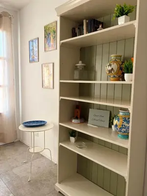 a book shelf with a table in a room at Aerial House in Palermo