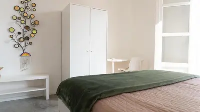 a bedroom with a bed with a green blanket at Aerial House in Palermo