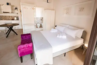 a bedroom with a white bed and a pink chair at Masalia Loft in Palermo