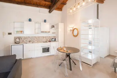 a kitchen and living room with a table and chairs at Masalia Loft in Palermo