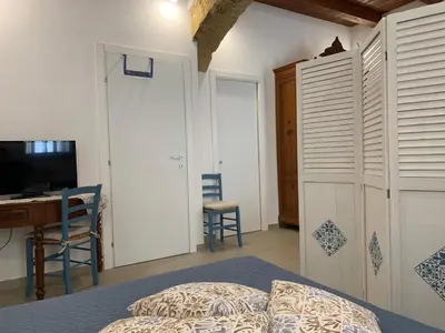 a bedroom with a bed and a table and a desk at Guzzari 75 Home in Castellammare del Golfo