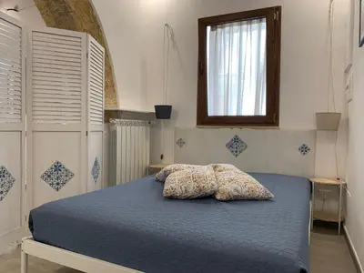 a bedroom with a blue bed with two pillows on it at Guzzari 75 Home in Castellammare del Golfo