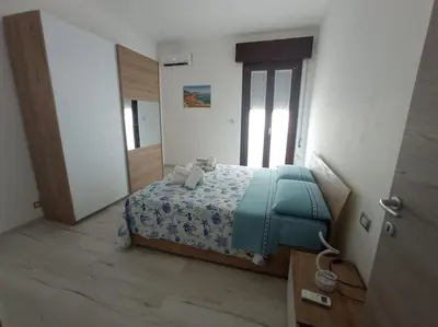 a bedroom with a bed with a blue blanket at Makari Sweet Sunsets in Macari