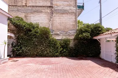 a building with a bunch of bushes next to a driveway at Vista Mare by DomuSicily in Cinisi