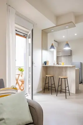 a kitchen and living room with a couch and stool at Maison169 in Palermo