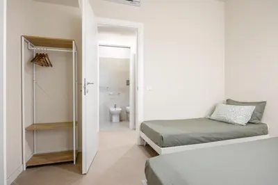 a bedroom with two beds and a bathroom at Maison169 in Palermo