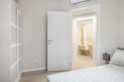 a bedroom with a sliding door leading to a bathroom at Maison169 in Palermo